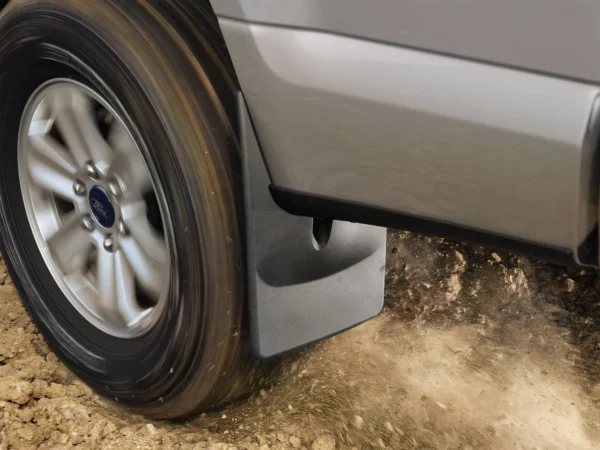 WeatherTech black front mud flaps installed on 2021 to 2024 models of Ford F150 truck, providing splash and debris protection on dirt road terrain, available at Scorpion Truck Stuff in Edmonton, Canada.